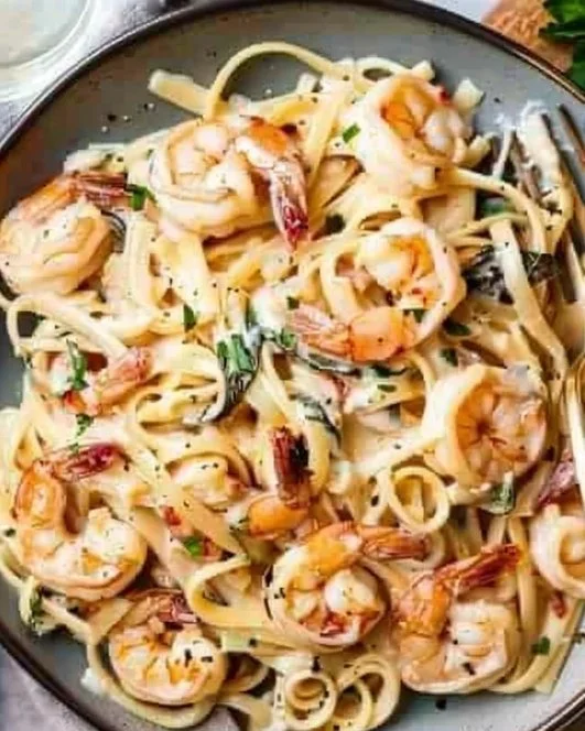 Creamy Tuscan shrimp linguine served in a bowl with herbs and parmesan