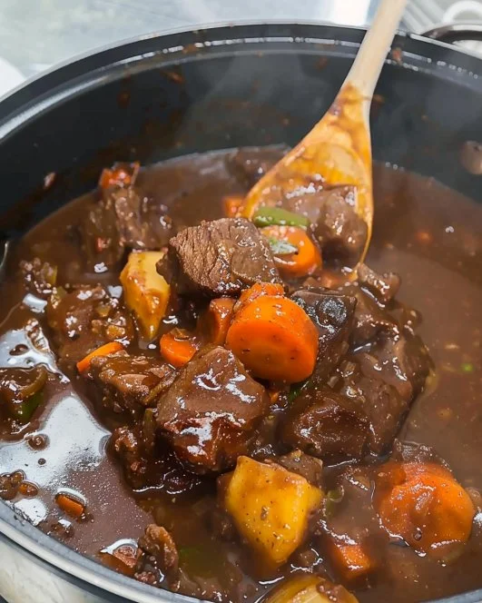 A delicious bowl of viral beef stew garnished with herbs and fresh vegetables.